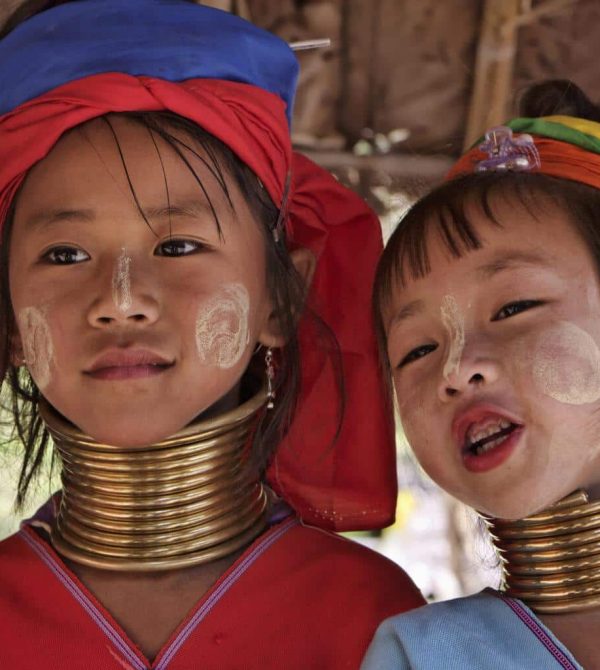 Thailand, Chiang Mai, Karen Long Neck hill tribe village (Kayan Lahwi), Long Neck young girls in traditional costumes. Women put brass rings on their neck when they are 5 or 6 years old and increase the number every year until their necks become longer as a symbol of beauty